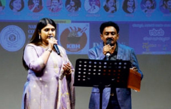 Dr. Pavithra singing a duet on a concert stage